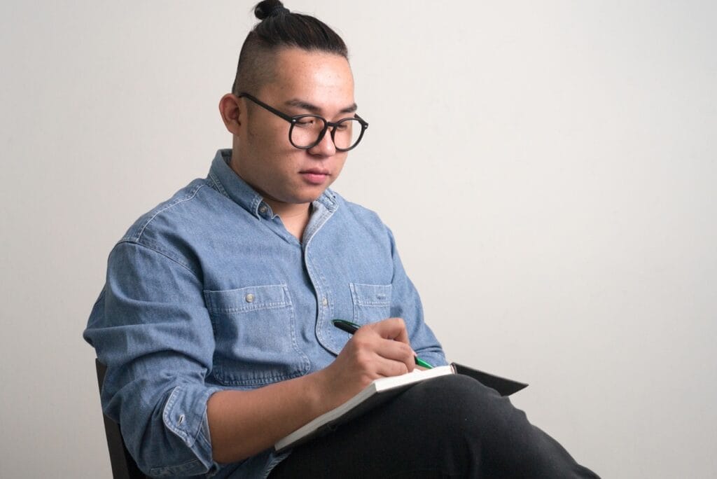 Man writing in journal to track eating patterns and cravings